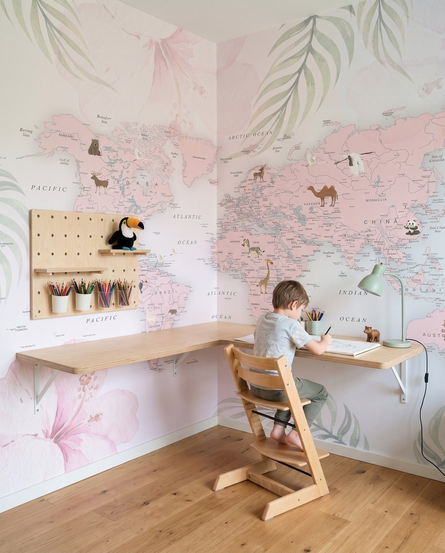Mapa-mundo entre folhas pastel num interior